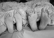 couple's feet at end of a bed