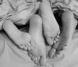 couple's feet over end of bed